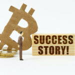 Bitcoin BTC symbol beside a sign reading 'Success Story'