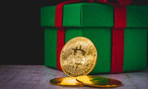 A bitcoin in front of a Christmas present