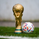The World Cup trophy with a football beside it